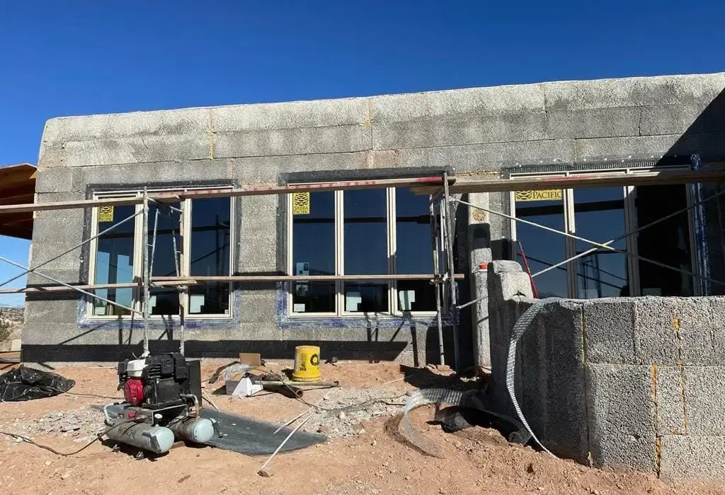 Concrete block house with scaffolding set up before stucco