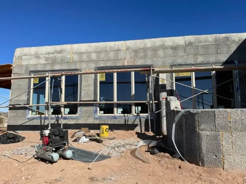 Concrete block house with scaffolding set up before stucco