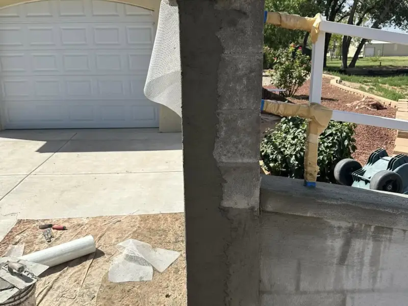 Concrete block pillar covered in a stucco brown coat with trim formed at the top