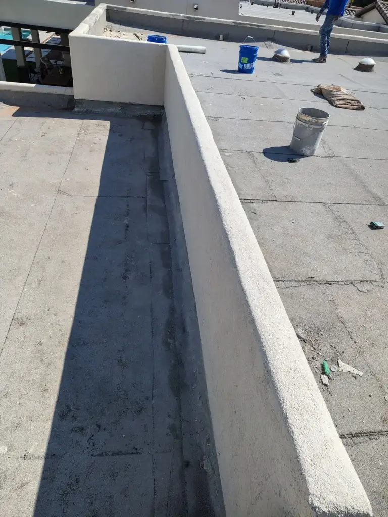 Finished smooth stucco parapet running along a flat roof