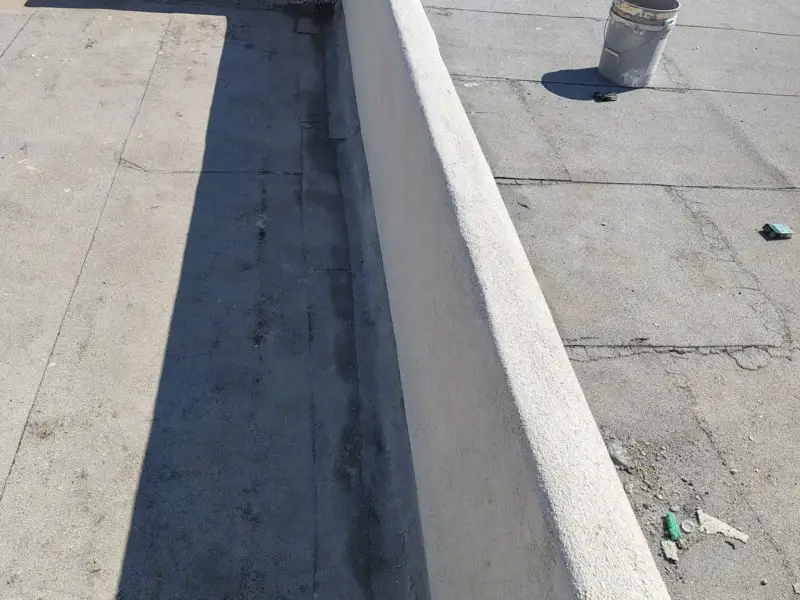 Finished smooth stucco parapet running along a flat roof