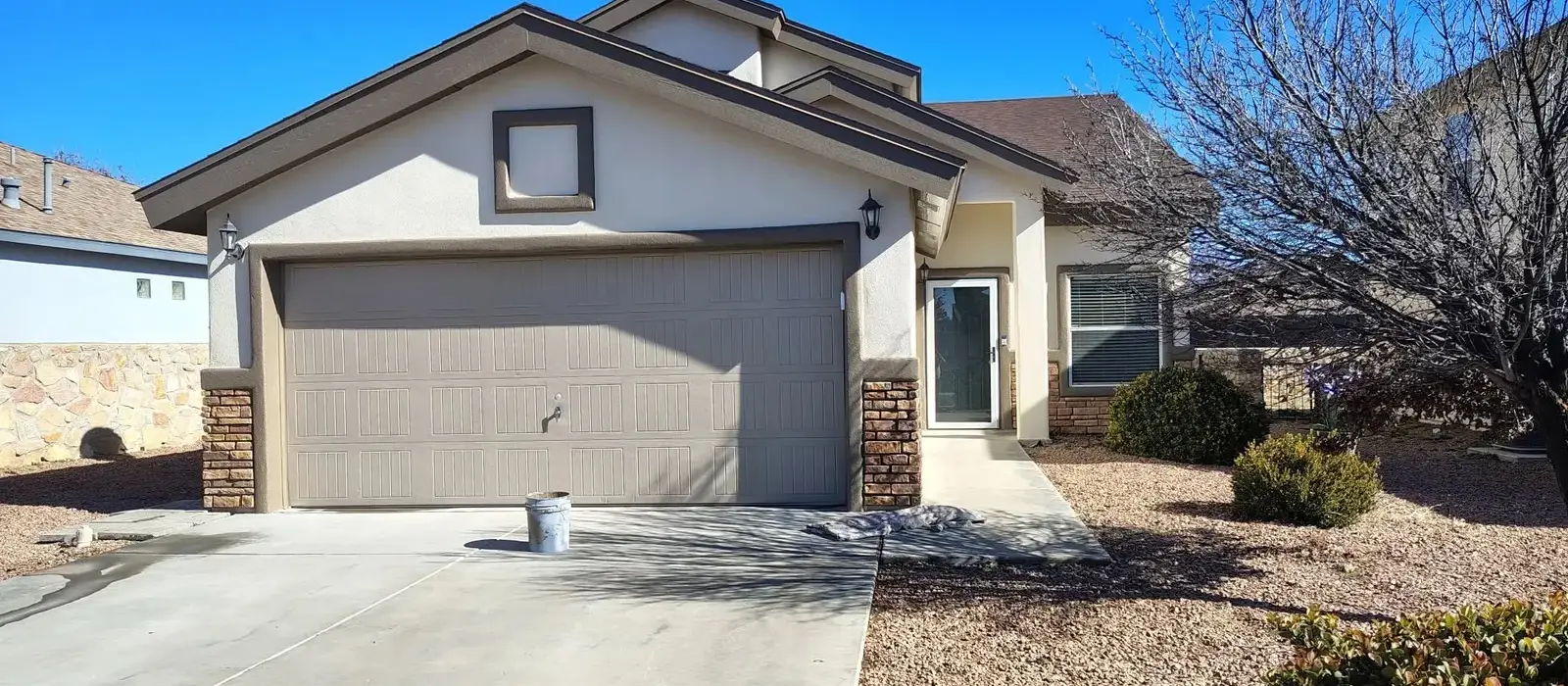 Front of a stucco home with a two-car garage after a fresh coat
