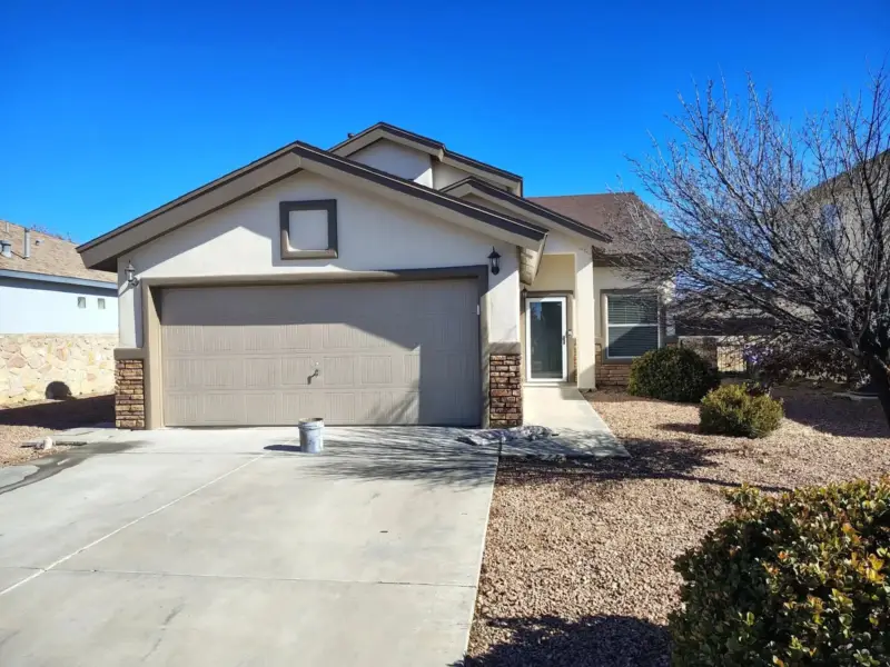 Front of a stucco home with a two-car garage after a fresh coat